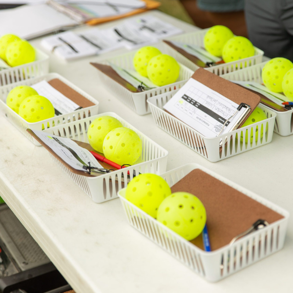 Pickleball tournament baskets with clipboard and pickleballs